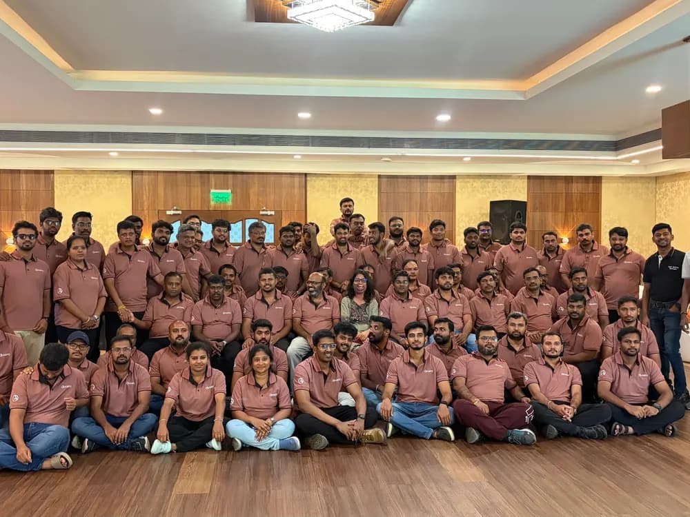 A large group of programme participants in matching shirts, gathered for a photograph at the end of a session