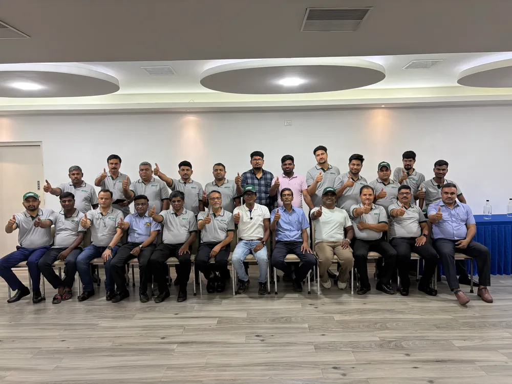 Participants seated together in a training room, giving a thumbs up to the camera